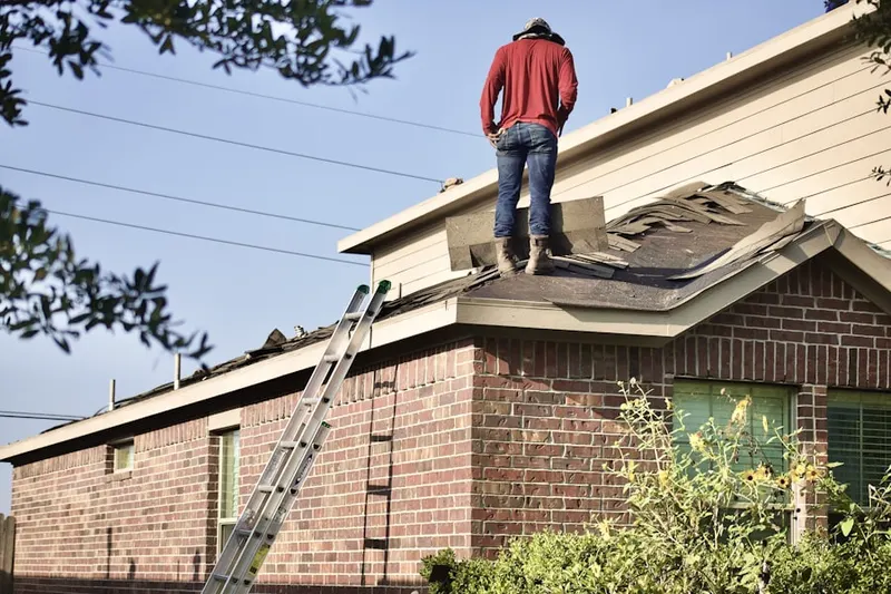 Professional roofer working on a residential roof in Rexis